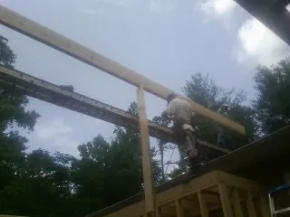 Carpenter setting a ridge beam over a new addition frame — Ice Dam Removal by Roofing Brothers in Downers Grove